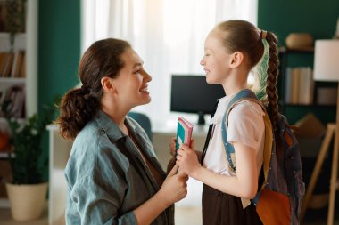 Mutlu aile okula hazırlanıyor. Annesi olan küçük bir kız..