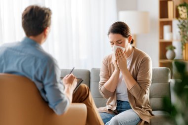 Psikolog resepsiyonundaki genç bayan hastaya danışmanlık.