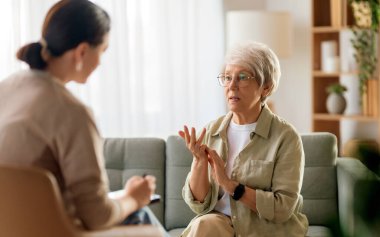 Psikolog resepsiyonundaki yaşlı kadın hastaya danışmanlık.