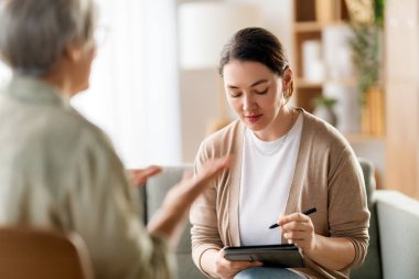 Psikolog resepsiyonundaki yaşlı kadın hastaya danışmanlık.