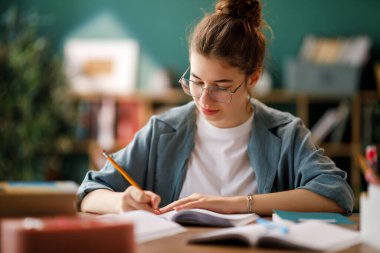 Okuldaki mutlu çocuk. Çocuk sınıfta öğreniyor ya da ev ödevi yapıyor.
