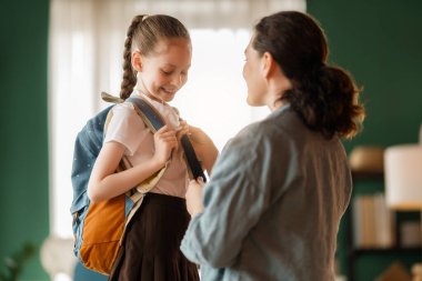 Mutlu aile okula hazırlanıyor. Annesi olan küçük bir kız..