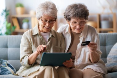 Kadınlar internetten alışveriş yapıyor. Üst sınıflar evde laptop ve kredi kartı kullanarak alışveriş yapıyorlar..