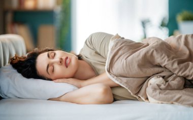 Güzel genç bir kadın evdeki yatak odasında uyuyor..