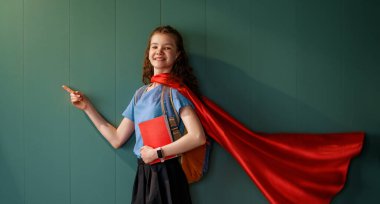 Süper kahraman bir öğrenci. Kitapları duvara dayamış bir kız öğrenci..