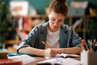 Okuldaki mutlu çocuk. Çocuk sınıfta öğreniyor ya da ev ödevi yapıyor.