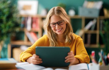 Okuldaki mutlu çocuk. Çocuk sınıfta öğreniyor ya da ev ödevi yapıyor.