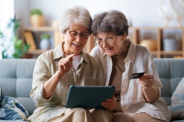 Kadınlar internetten alışveriş yapıyor. Üst sınıflar evde laptop ve kredi kartı kullanarak alışveriş yapıyorlar..