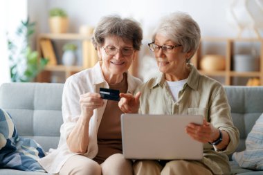 Kadınlar internetten alışveriş yapıyor. Üst sınıflar evde laptop ve kredi kartı kullanarak alışveriş yapıyorlar..