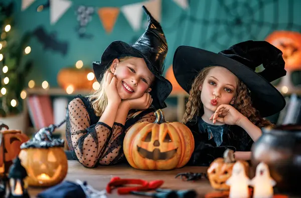 Cadı kostümlü iki kız Cadılar Bayramı 'nı kutluyor. Balkabaklı çocuklar