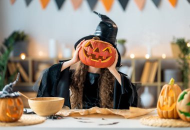 Cadı kostümlü kız Cadılar Bayramı 'nı kutluyor. Balkabaklı çocuk.