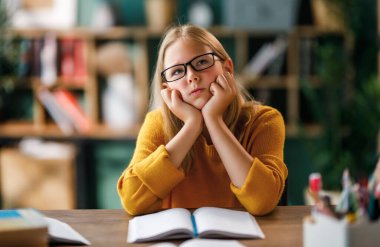 Okuldaki çocuk. Çocuk sınıfta öğreniyor ya da ev ödevi yapıyor.