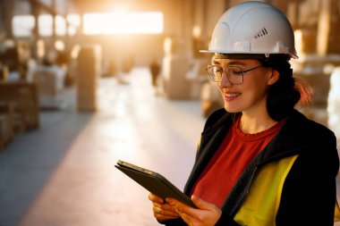 Beyaz şapkalı genç kadın depoda çalışıyor.