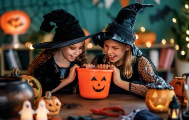 Cadı kostümlü iki kız Cadılar Bayramı 'nı kutluyor. Balkabaklı çocuklar