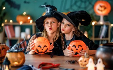 Cadı kostümlü iki kız Cadılar Bayramı 'nı kutluyor. Balkabaklı çocuklar