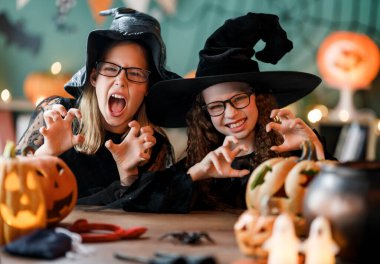 Cadı kostümlü iki kız Cadılar Bayramı 'nı kutluyor. Balkabaklı çocuklar