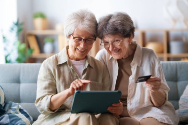 Kadınlar internetten alışveriş yapıyor. Üst sınıflar evde laptop ve kredi kartı kullanarak alışveriş yapıyorlar..