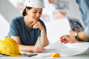 İnşaat alanında planlar üzerinde çalışan mimarlardan oluşan bir ekip..