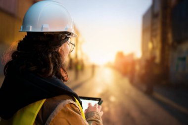 Beyaz şapkalı kadın endüstriyel mühendis konteyner terminalinde çalışıyor..