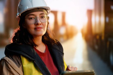 Beyaz şapkalı kadın endüstriyel mühendis konteyner terminalinde çalışıyor..