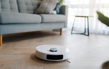 Ahşap zeminde beyaz robot elektrikli süpürge. Akıllı temizlik teknolojisi