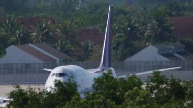 PHUKET, THAILAND - NOVEMBER 27, 2019: Boeing 747 of Thai Airways at Phuket Airport, front view. Palm trees surround the airport airfield. Tourism and travel concept