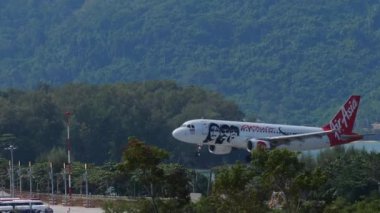 PHUKET, THAILAND - NOVEMBER 27, 2019: Side view, Airbus A320 of AirAsia landing at Phuket airport. Tourism and travel concept