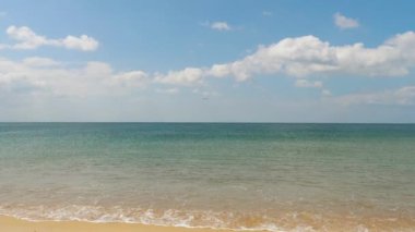 Footage of ocean waves roll on the sandy shore. Seascape, Phuket island. Jet plane approaching to land over the ocean