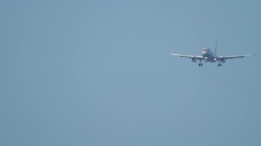Footage of a jet passenger airliner approaching to land in the blue sky, long shot