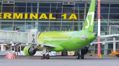 KAZAN, RUSSIA - AUGUST 05, 2022: S7 Airlines plane at the airport terminal after boarding passengers. Tug at the airport pull the plane to the runway