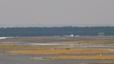 Long shot of passenger jet plane braking after landing. Unrecognizable airliner arriving. Panoramic view of the airfield. Tourism and travel concept.