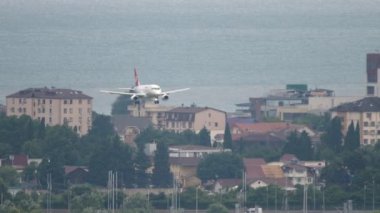 SOCHI, RUSSIA - JULY 27, 2022: Long shot of civil plane Yamal Airlines landing at Sochi International Airport. Tourism and travel concept