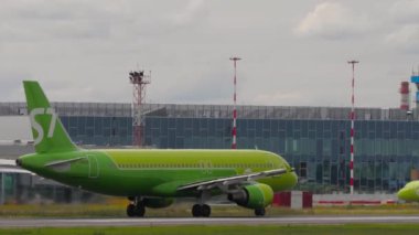 NOVOSIBIRSK, RUSSIAN FEDERATION - JULY 15, 2022: Airplane of S7 Airlines picking up speed before takeoff at Tolmachevo airport, side view. Tourism and aviation concept