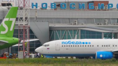 NOVOSIBIRSK, RUSSIAN FEDERATION - JULY 15, 2022: Boeing 737, RA-73226 of Pobeda taxiing on the apron at Tolmachevo airport, Novosibirsk. Airplane Russian Airlines, side view