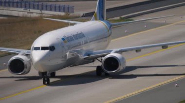 FRANKFURT AM MAIN, GERMANY - JULY 19, 2017: Ukraine International Airlines Boeing 737 taxiing to the terminal, to the runway at Frankfurt Airport, Germany. Tourism and travel concept