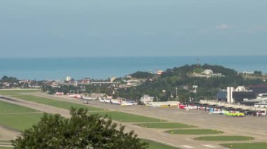 SOCHI, RUSSIA - JULY 29, 2022: Airfield at Sochi Airport. Timelapse of aviation traffic. Panoramic view of the airport runway and the sea in the background