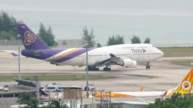 PHUKET, THAILAND - NOVEMBER 28, 2017: Boeing 747, HS-TGF of Thai Airways taxiing on the runway of Phuket airport. Airport and sea background. Tourism and travel concept