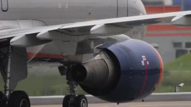 Jet passenger aircraft rides on the taxiway, side view. Close-up, aircraft on the airfield. Tourism and travel concept.