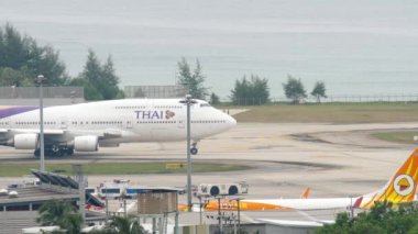 PHUKET, THAILAND - NOVEMBER 28, 2017: Boeing 747 of Thai Airways taxiing on runway of Phuket airport. Passenger huge jumbo jet, sea background. Tourism and travel concept