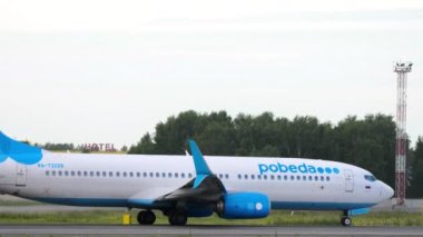 NOVOSIBIRSK, RUSSIAN FEDERATION - JULY 15, 2022: Side view of Boeing 737 of Pobeda Airlines acceleration and takeoff at Tolmachevo airport. Tourism and travel concept