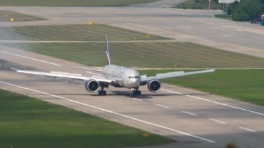 SOCHI, RUSSIA - AUGUST 03, 2022: Boeing 777 of Aeroflot landing and braking at Sochi airport, front view. Widebody passenger airliner arrival, airfield view