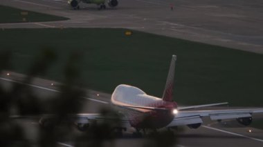 SOCHI, RUSSIA - JULY 29, 2022: Boeing 747 of Rossiya on the runway speed up before takeoff. Jumbo jet departure at dawn, rear view