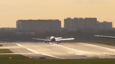 Airplane on the runway in the sun glare set speed for departure. Rear view of a silhouette of an airliner takeoff