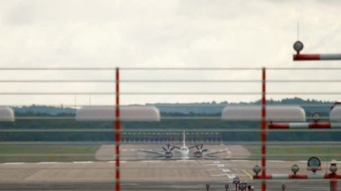 Turboprop aircraft braking after landing. Front view through the landing lights on the runway