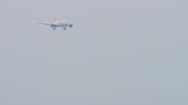 SOCHI, RUSSIA - AUGUST 03, 2022: Boeing 777 of Nordwind Airlines approaching before landing at Sochi airport. Airplane flies, long shot. Tourism and travel concept