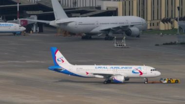 SOCHI, RUSSIA - JULY 30, 2022: Passenger plane of Ural Airlines towing on the runway at Sochi airport. Air flight departure. Civilian aircraft on the airfield. Tourism and travel concept