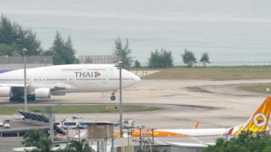 PHUKET, THAILAND - NOVEMBER 28, 2017: Boeing 747 of Thai Airways taxiing on runway at Phuket airport. Passenger huge jumbo jet, sea background. Tourism and travel concept