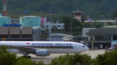 PHUKET, THAILAND - NOVEMBER 28, 2019: Boeing 777, 9V-SVC of Singapore Airlines taxiing to Phuket airport terminal, side view. Tourism and travel concept