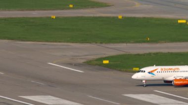 SOCHI, RUSSIA - AUGUST 04, 2022: Sukhoi Superjet 100-95LR, RA-89095 of Azimuth taxiing to the runway at Sochi airport, side and rear view. Azimuth Russian airline. Tourism and travel concept