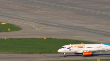 SOCHI, RUSSIA - AUGUST 04, 2022: Airplane Sukhoi Superjet 100 of Azimuth rides on the taxiway at Sochi airport, side view. Azimuth Russian airline taxiing. Tourism and travel concept